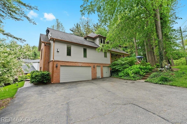 5721 Coralwood Ct, Commerce Twp, MI 48382 - view of front of property featuring a garage, brick siding, and driveway