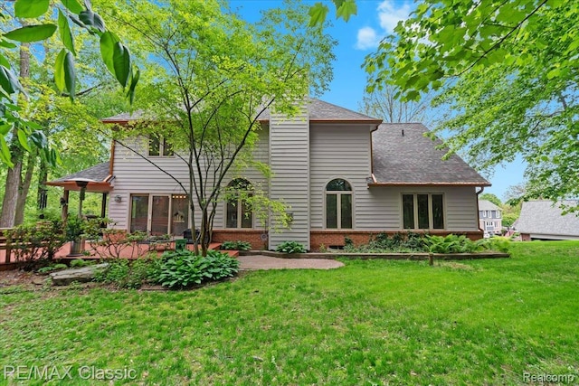 5721 Coralwood Ct, Commerce Twp, MI 48382 - back of property featuring a patio area, a lawn, a shingled roof, and brick siding
