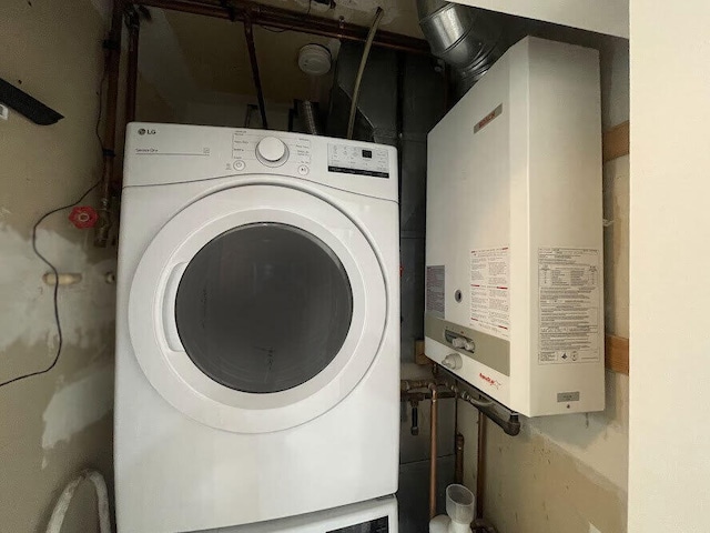 clothes washing area featuring washer / clothes dryer, laundry area, and tankless water heater