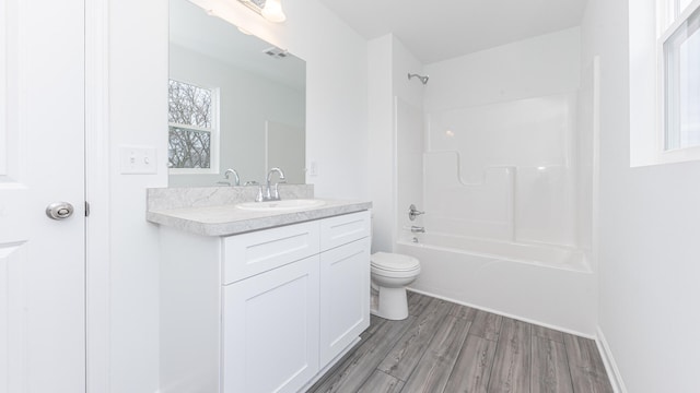 full bathroom featuring tub / shower combination, wood finished floors, toilet, and vanity