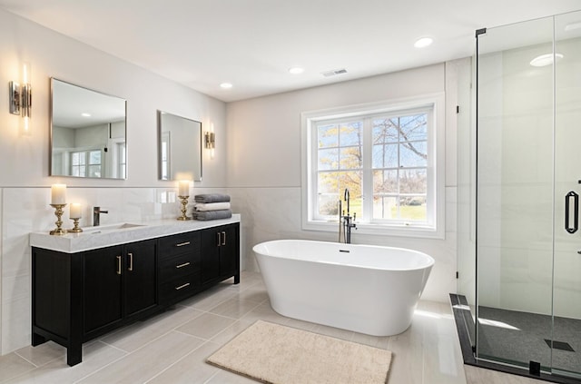 6376 Sterling Dr, Newport, MI 48166 - full bathroom featuring a freestanding tub, vanity, visible vents, tile walls, and a stall shower
