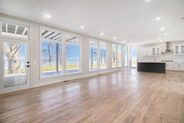 6376 Sterling Dr, Newport, MI 48166 - unfurnished living room with recessed lighting, light wood-style floors, visible vents, a water view, and a sink