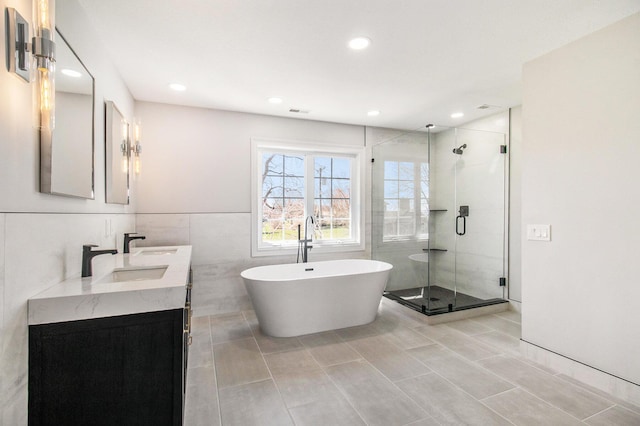6376 Sterling Dr, Newport, MI 48166 - bathroom featuring a shower stall, a freestanding tub, vanity, recessed lighting, and tile walls