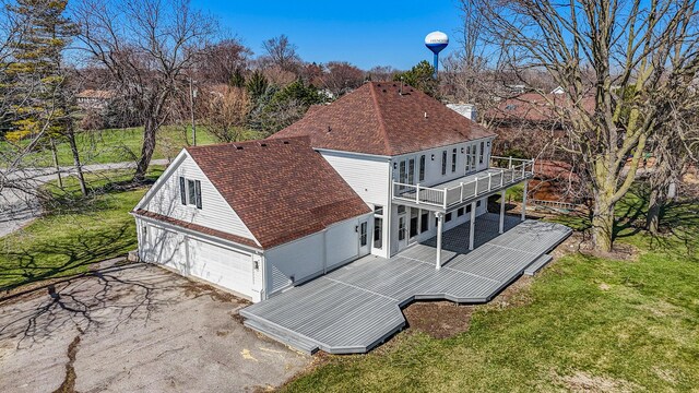 6376 Sterling Dr, Newport, MI 48166 - back of house featuring roof with shingles, a balcony, a detached garage, a wooden deck, and a lawn