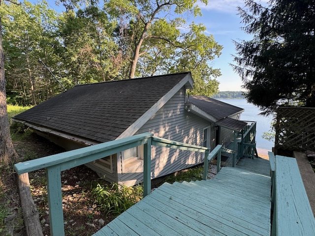 7075 N Poplar Rd, Michigan, MI 49411 - view of side of home featuring a shingled roof and a deck with water view