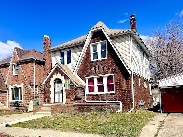 16150 Birwood St, Detroit, MI 48221 - tudor-style house featuring brick siding, a front yard, and a chimney