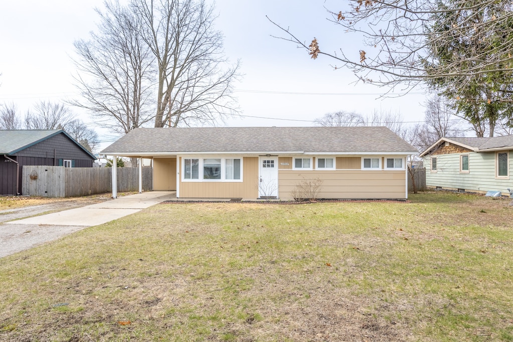 2353 Riverside Dr, Port Huron, MI 48060 - ranch-style home with concrete driveway, a front yard, a carport, and fence