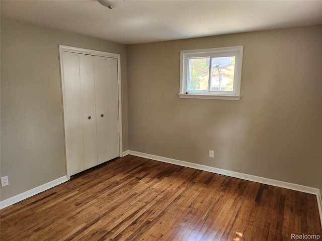 1260 Hira St, Waterford, MI 48328 - unfurnished bedroom with a closet and dark wood-style floors