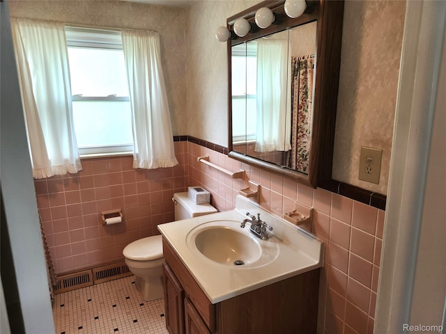 1260 Hira St, Waterford, MI 48328 - bathroom featuring tile patterned floors, vanity, tile walls, and a wainscoted wall