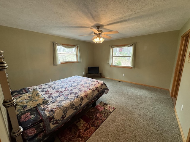 bedroom with carpet floors, baseboards, a ceiling fan, and a textured ceiling