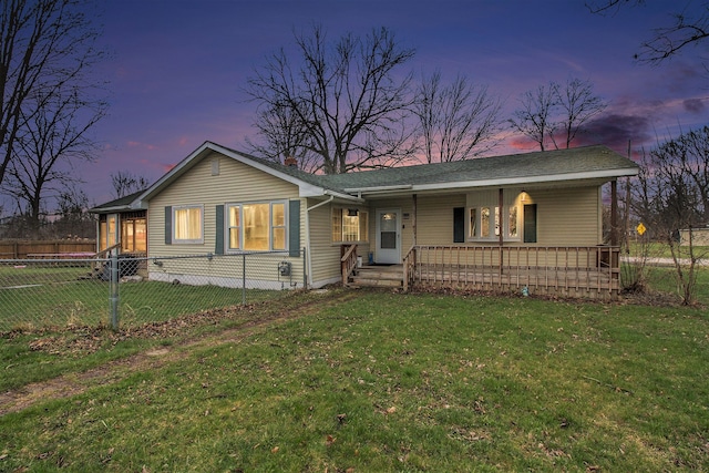 ranch-style home featuring a yard, a porch, and fence