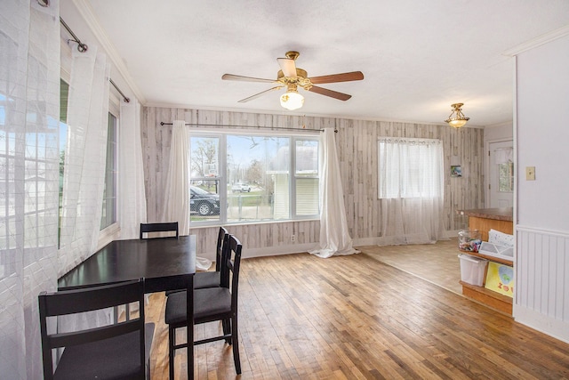 dining room featuring ornamental molding, a ceiling fan, plenty of natural light, and hardwood / wood-style flooring