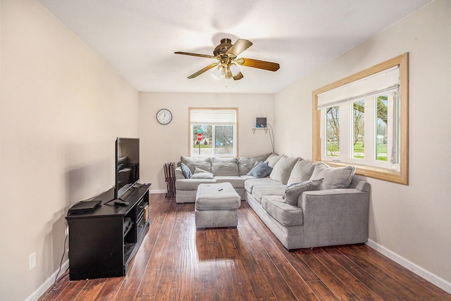 living area with ceiling fan, baseboards, and dark wood finished floors