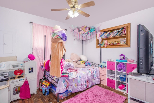 bedroom with ceiling fan, wood finished floors, and electric panel
