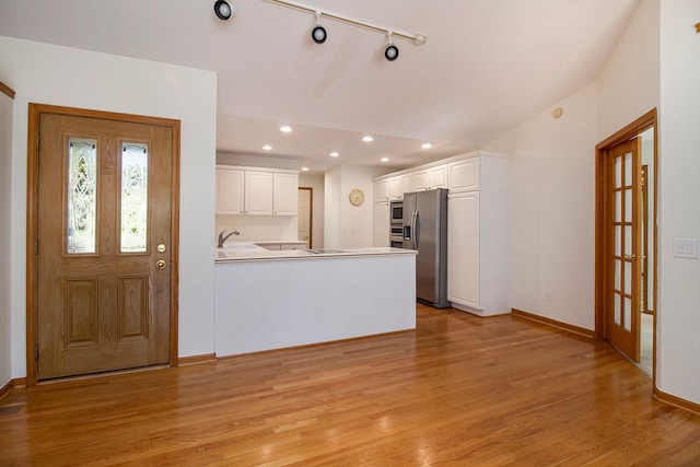 11183 Bayshore Ct, Clarkston, MI 48348 - kitchen with stainless steel fridge with ice dispenser, a peninsula, white cabinetry, light wood-type flooring, and recessed lighting