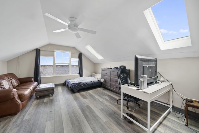 bedroom with baseboards, a ceiling fan, lofted ceiling with skylight, and wood finished floors