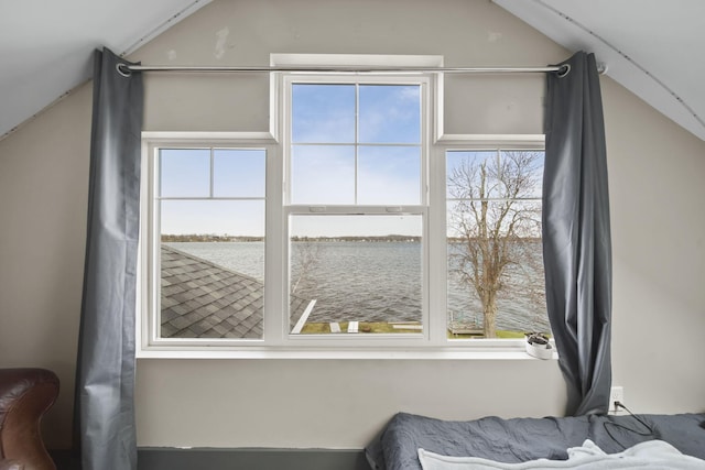 interior space with vaulted ceiling and a water view