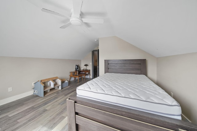 bedroom featuring ceiling fan, baseboards, wood finished floors, and lofted ceiling