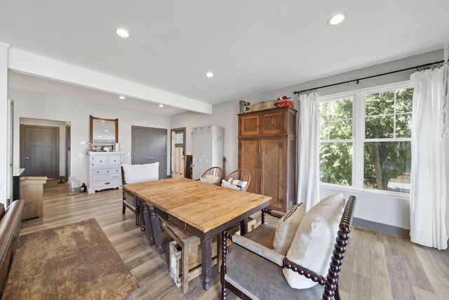 dining space featuring recessed lighting, light wood finished floors, and beamed ceiling