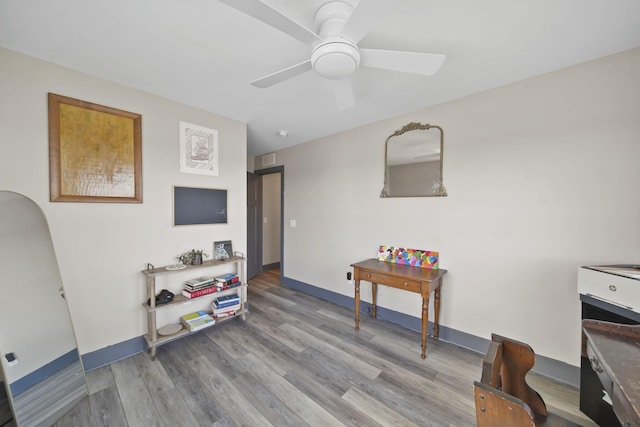 interior space with ceiling fan, baseboards, visible vents, and wood finished floors