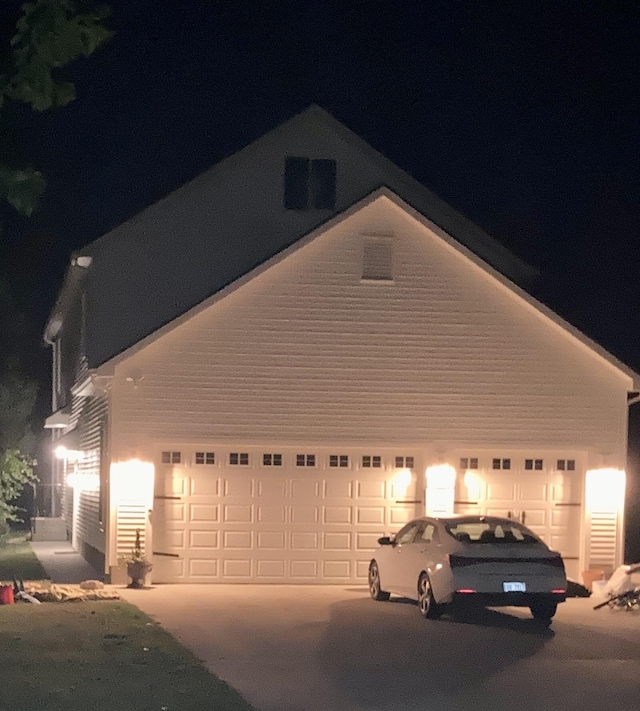 garage at twilight featuring driveway