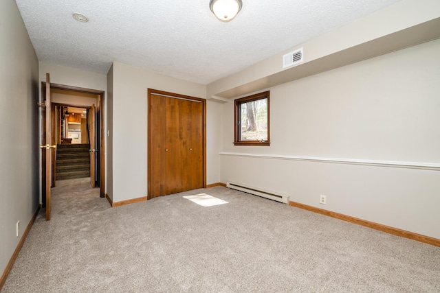 2532 Ridgewood Trl, Berrien Springs, MI 49103 - unfurnished bedroom featuring visible vents, a closet, a textured ceiling, carpet flooring, and a baseboard heating unit