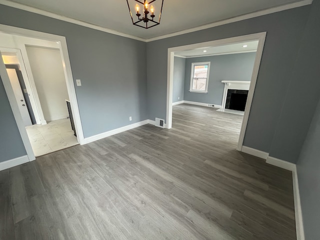 4651 Berkshire St, Detroit, MI 48224 - empty room with visible vents, baseboards, a chandelier, crown molding, and dark wood-type flooring