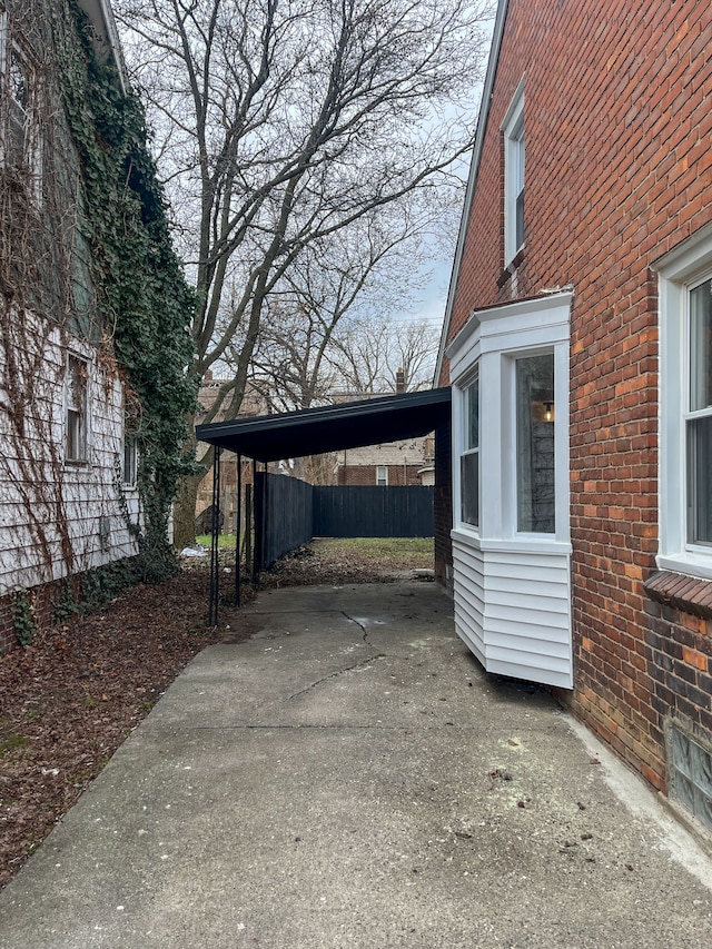 4651 Berkshire St, Detroit, MI 48224 - view of car parking with driveway, fence, and an attached carport