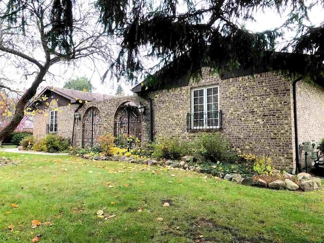 view of front facade with a front lawn and brick siding