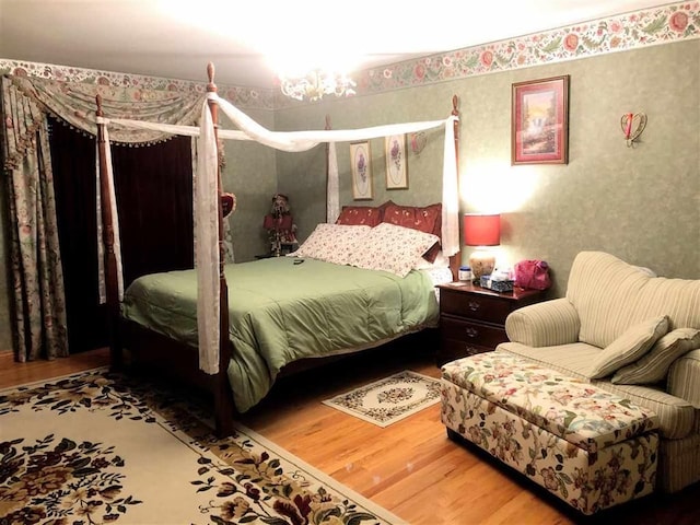 bedroom featuring wood finished floors and wallpapered walls