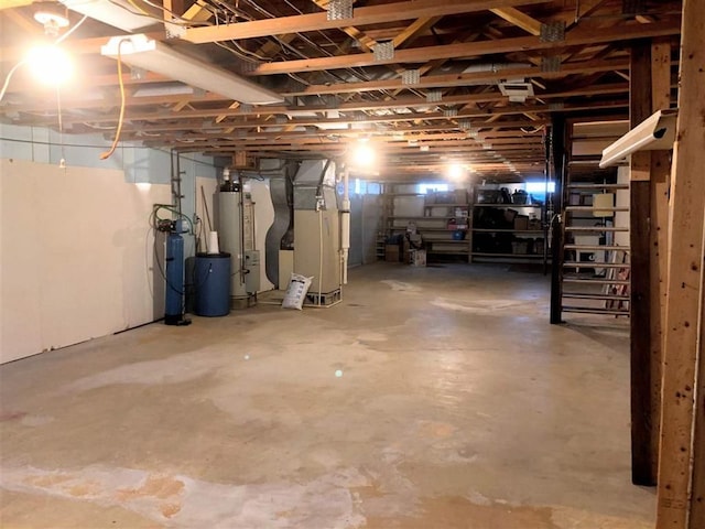 unfinished below grade area featuring gas water heater, heating unit, and a water softener
