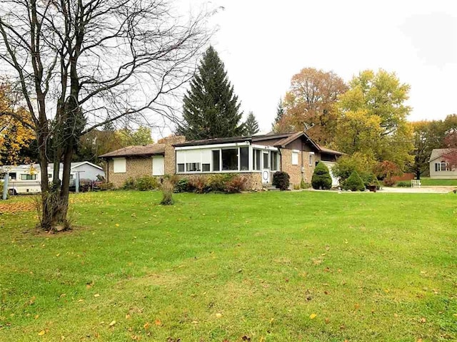 ranch-style home featuring a front lawn and brick siding