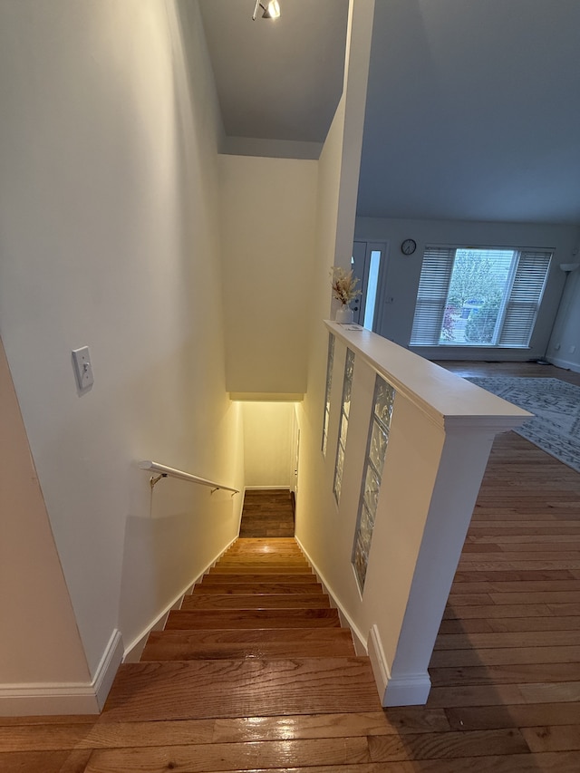 stairway with wood-type flooring and baseboards