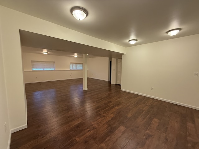 below grade area featuring baseboards and dark wood-style floors
