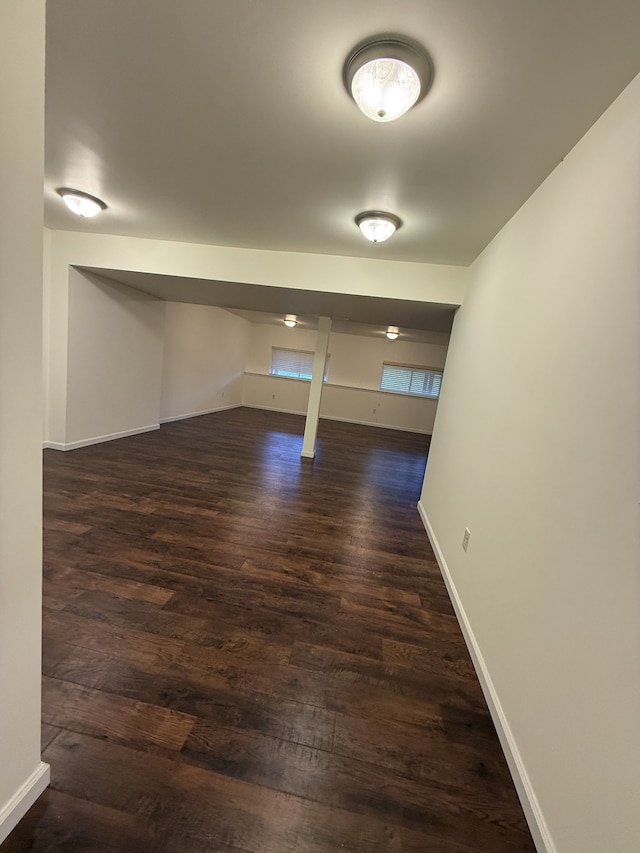below grade area featuring baseboards and dark wood-style flooring