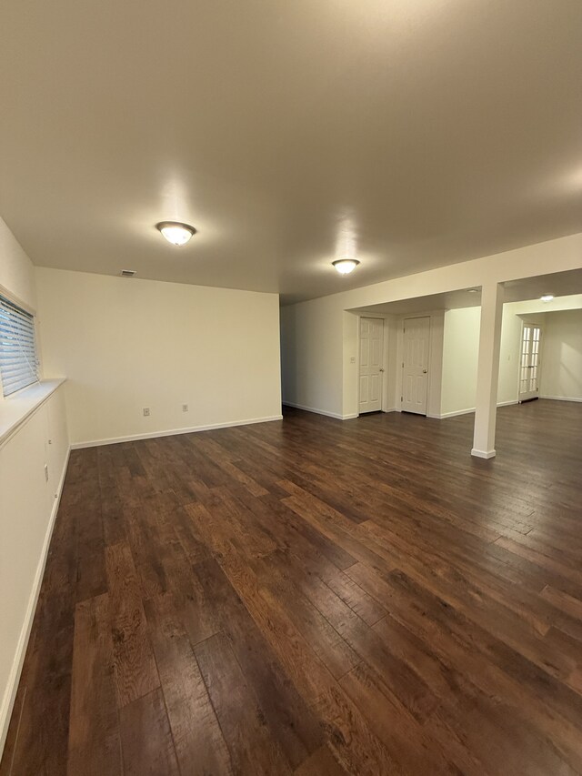 finished below grade area with baseboards and dark wood finished floors