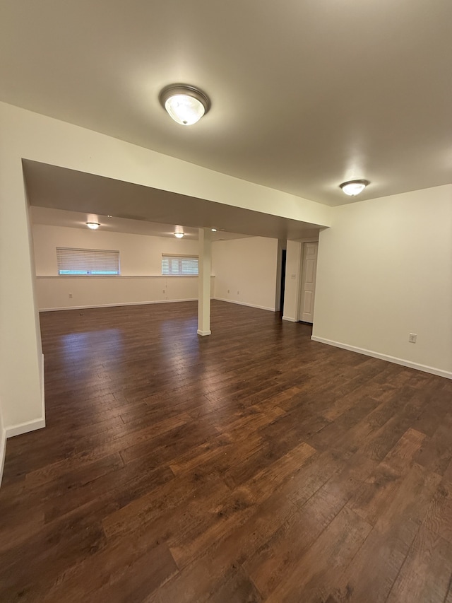 below grade area with baseboards and dark wood finished floors