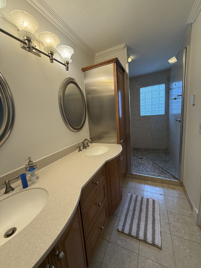 bathroom featuring double vanity, a sink, tile patterned floors, and tiled shower