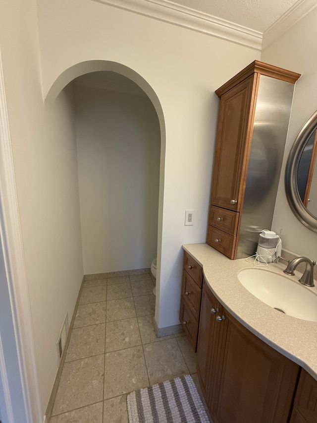bathroom featuring visible vents, crown molding, vanity, toilet, and tile patterned floors