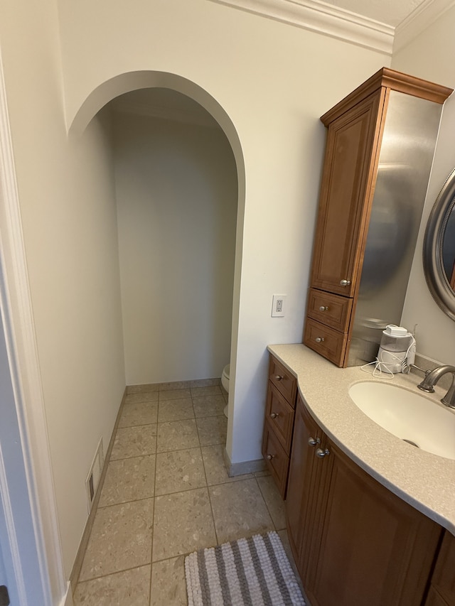 bathroom featuring vanity, ornamental molding, tile patterned flooring, visible vents, and toilet