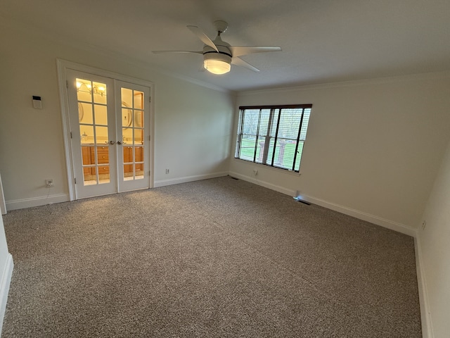 carpeted empty room featuring baseboards, ornamental molding, a ceiling fan, and french doors