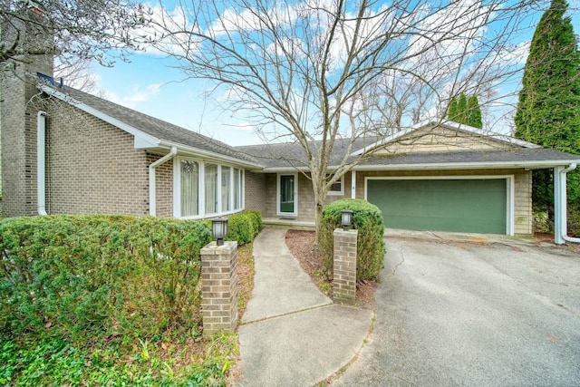 single story home featuring brick siding, an attached garage, and driveway