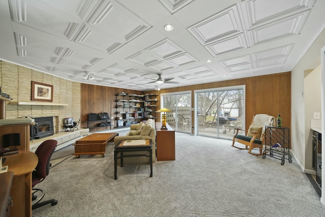 interior space featuring wooden walls, ceiling fan, and a brick fireplace