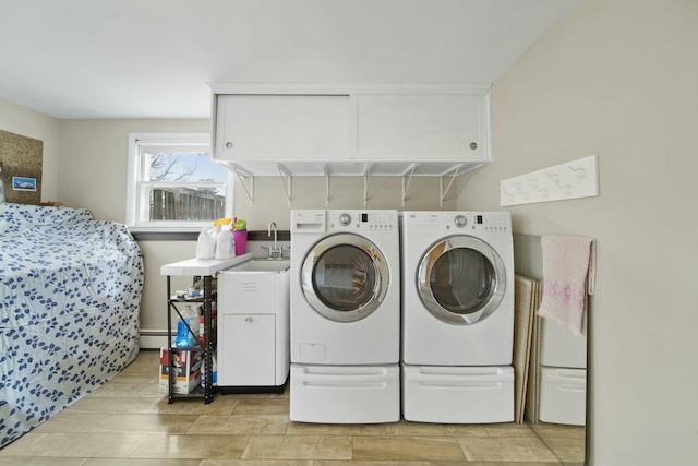 laundry room featuring baseboard heating, a sink, washing machine and clothes dryer, and cabinet space