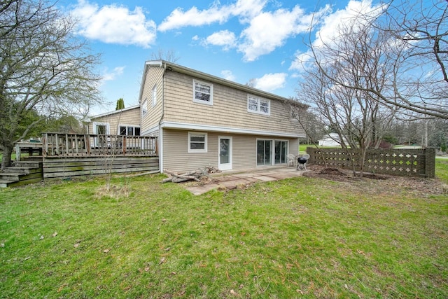back of property with a patio, a wooden deck, and a lawn