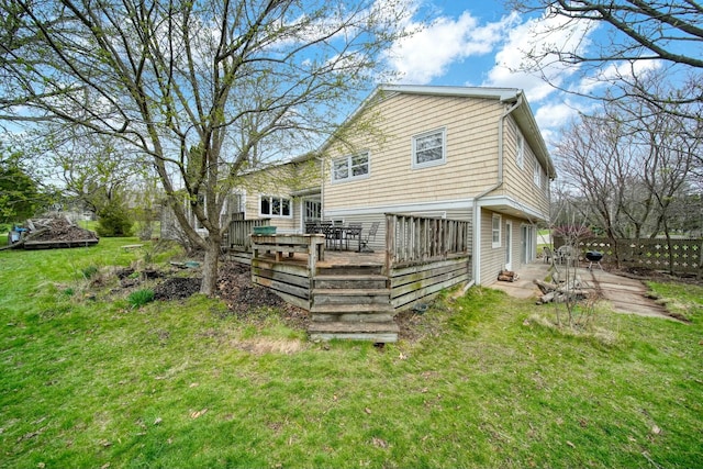 rear view of property with a yard and a deck