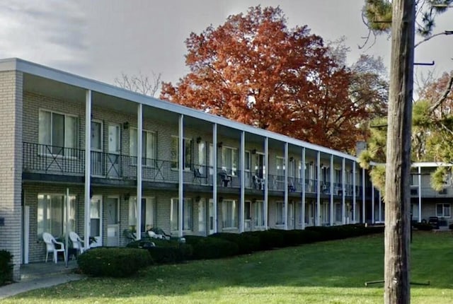 exterior space featuring a yard and brick siding