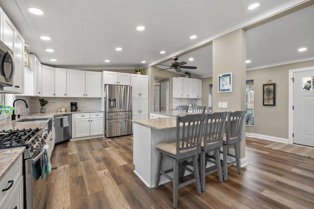 kitchen with crown molding, backsplash, dark wood finished floors, and stainless steel appliances