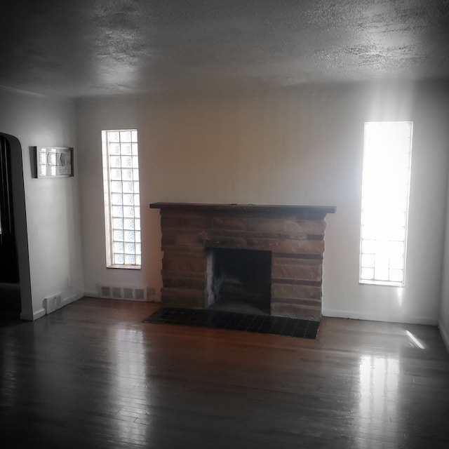 20209 Stotter St, Detroit, MI 48234 - unfurnished living room with a fireplace with flush hearth, a textured ceiling, wood finished floors, and visible vents