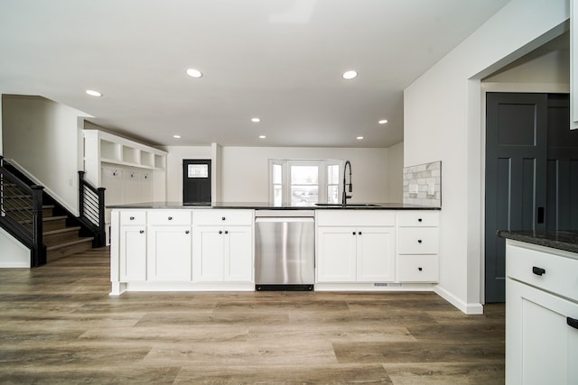 6522 Ellinwood Dr, White Lake, MI 48383 - kitchen featuring dark countertops, white cabinets, light wood-style floors, dishwasher, and a sink